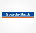 Blaues Rechteck mit weißem Text „Sparda-Bank“, darunter ein oranger Streifen auf weißem Hintergrund.