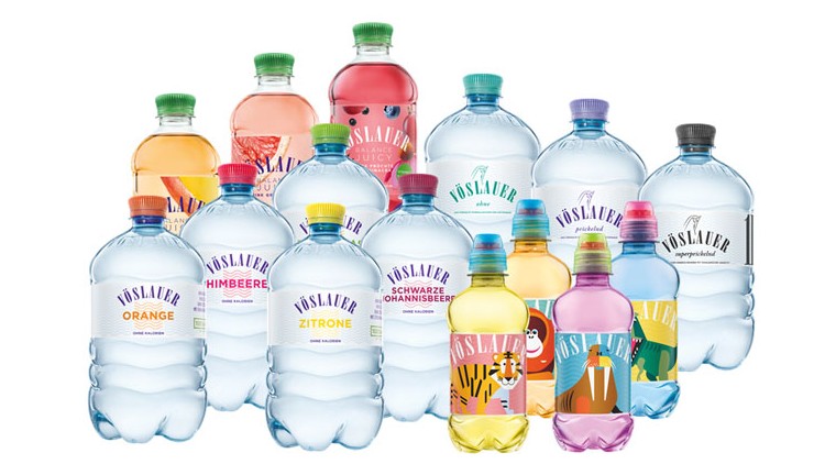 Flaschen verschiedener Vöslauer-Mineralwasser-Sorten in unterschiedlichen Farben und Designs stehen dicht beieinander.
