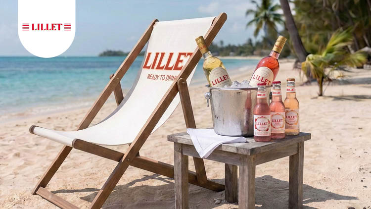 Ein weißer Liegestuhl mit rotem Schriftzug „LILLET“, ein Holztisch mit Getränkeflaschen und Eiskübel, umgeben von Palmen und Sandstrand.