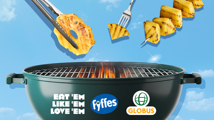 Grüner Grill mit Flammen, über ihm schwebende gegrillte Ananasstücke auf Spießen, Logos von Fyffes und GLOBUS, Text: Eat 'Em Like 'Em Love 'Em.