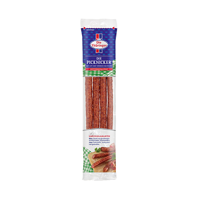 Vier dünne, verpackte Würstchen in einer länglichen Plastikverpackung mit blauem, grünem und rotem Design, Text „Die Thüringer“.