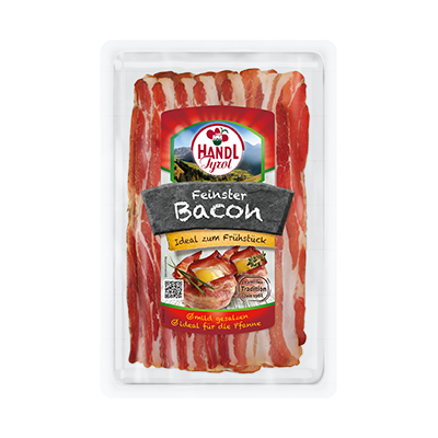 Eine Plastikverpackung enthält dünne, rote und weiße Speckstreifen, Text: „Handl Tyrol, Feinster Bacon, Ideal zum Frühstück“.