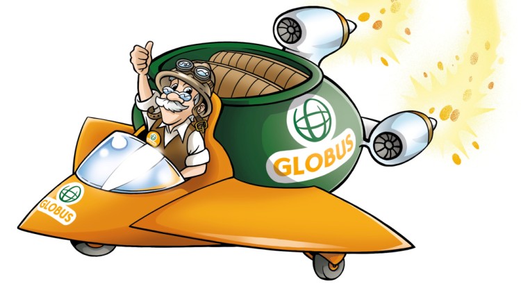 Professor Globus sitzt lächelnd im GLOBUS-Raumschiff mit orangener Spitze und hebt den Daumen, während goldene Funken hinter ihm fliegen.