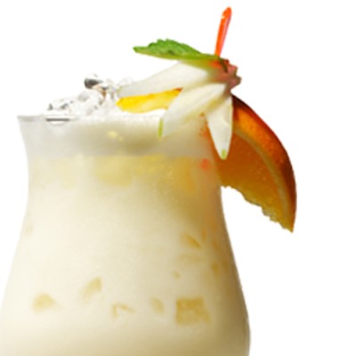 Ein hochformatiges Glas mit cremigem Cocktail, Eiswürfeln, Orangenscheibe, Apfelspalte, Minzblatt und Trinkhalm.
