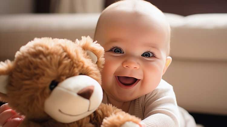 Ein lächelndes Kleinkind hält ein Plüsch-Teddy in den Händen, im Hintergrund sind unscharfe Möbel zu sehen.