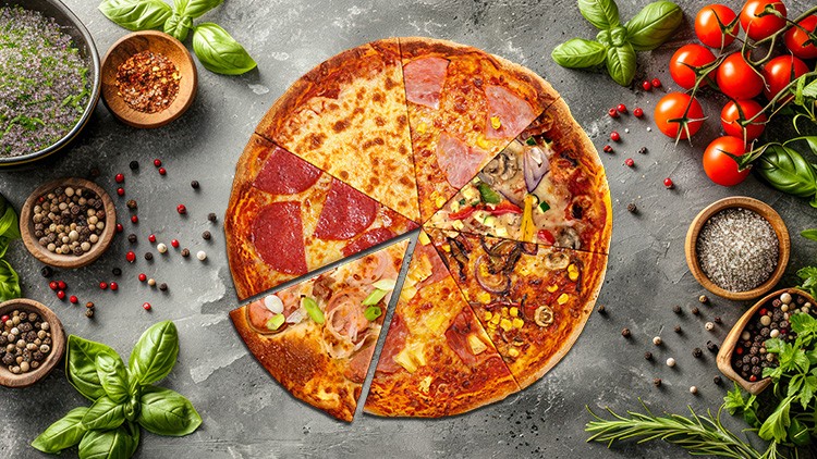 Pizza mit acht unterschiedlichen Stücken, umgeben von frischen Kräutern, Gewürzen und Tomaten auf grauem Untergrund.