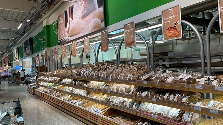 Brottheke im GLOBUS-Markt mit mehreren Regalen voller verpackter Brote und Preisschildern über den Produkten.