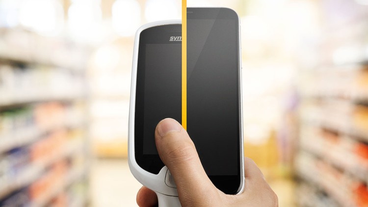 Hand hält ein Scan-&-Go-Gerät vor unscharfen Regalen in einem Supermarkt, Bildschirm zeigt eine gelbe vertikale Linie.