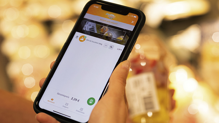 Eine Hand hält ein Smartphone mit geöffneter mein GLOBUS App und zeigt einen Einkaufsartikel im Warenkorb für 2,29 Euro.