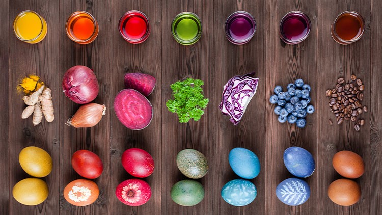 Bunte Ostereier, gefärbt mit natürlichen Zutaten wie Kurkuma, Zwiebeln, Roter Bete, Petersilie, Rotkohl und Blaubeeren.