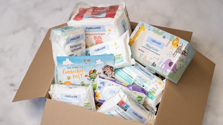 Offener Karton mit verschiedenen naturvitz-Produkten wie Feuchttücher, Wickelunterlagen und Verpackungen mit bunten Tiermotiven.