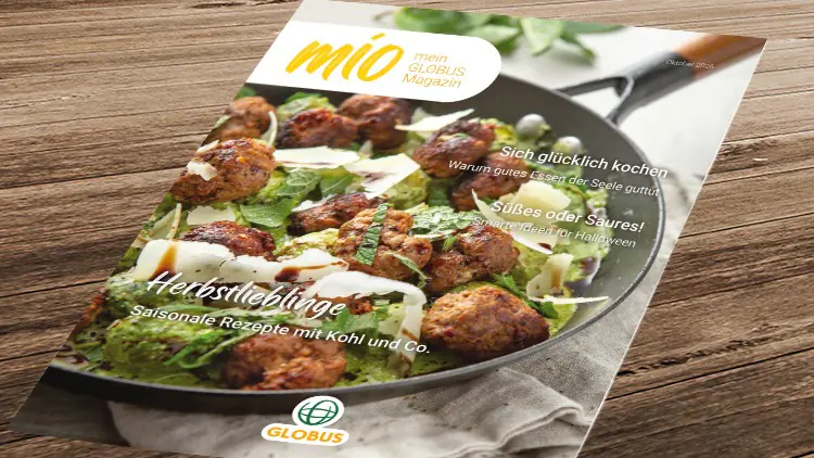 Pfanne mit Fleischbällchen, frischem grünem Gemüse und Parmesan, darauf Text: „mio mein GLOBUS Magazin Herbstlieblinge“.