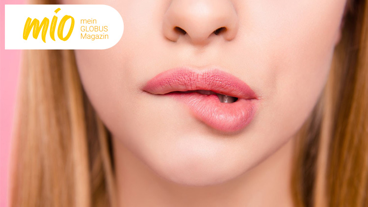 Unterer Gesichtsausschnitt mit leicht geschlossenen rosa Lippen, oben links das mio mein GLOBUS Magazin Logo auf weißem Hintergrund.
