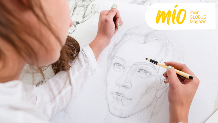 Person zeichnet mit einem gelben Bleistift auf weißem Papier, oben rechts steht „mio mein GLOBUS Magazin“ in gelber Schrift.