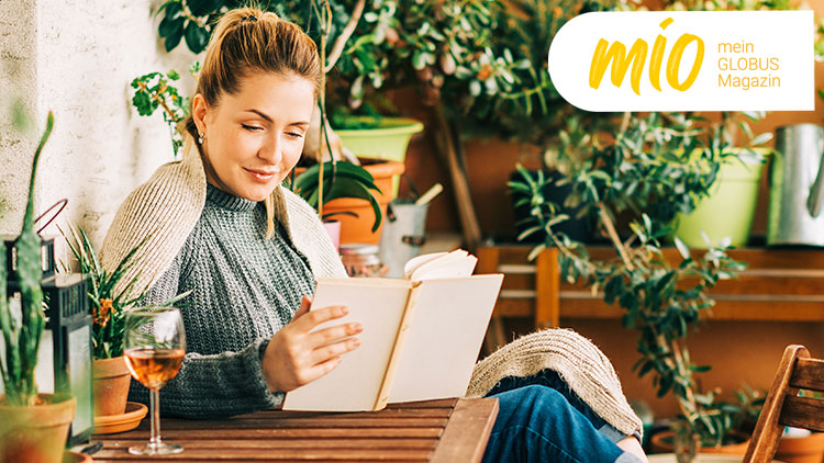 Person sitzt umgeben von vielen Pflanzen und liest ein Buch, oben rechts steht „mio mein GLOBUS Magazin“.