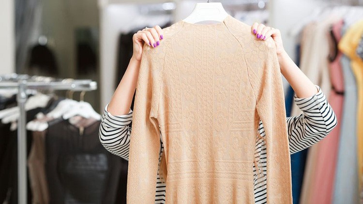 Frau betrachtet einen Pullover