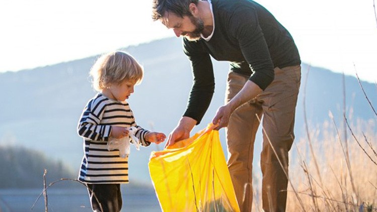 Vater sammelt mit Sohn Müll ein