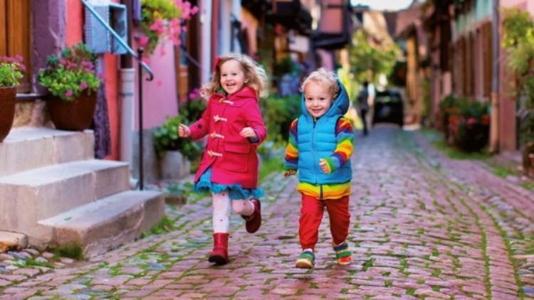 2 Kinder laufen durch eine Straßengasse