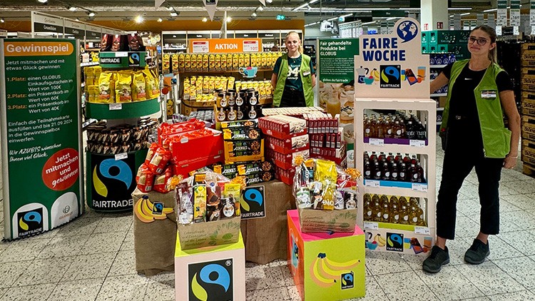 Ein Verkaufsstand mit Fairtrade-Produkten, Bannern zur Fairen Woche und einem Gewinnspiel im my GLOBUS Markt.