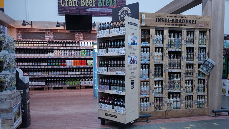 Regal mit Flaschen der Insel-Brauerei und weitere Getränkereihen in einer Craft Beer Arena mit Ziegelwand-Optik.