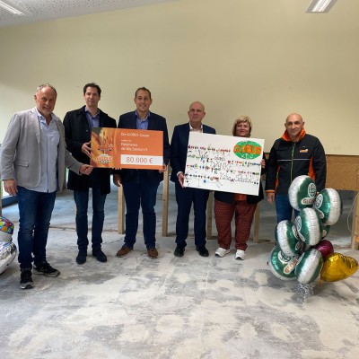 Sechs Personen halten zwei große Tafeln mit 80.000 Euro und einem Dankeschriftzug, daneben GLOBUS-Luftballons und Geschenke.