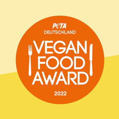 Oranger Kreis mit weißem Text „PETA Deutschland Vegan Food Award 2022“, Messer und Gabel, auf gelbem Hintergrund.