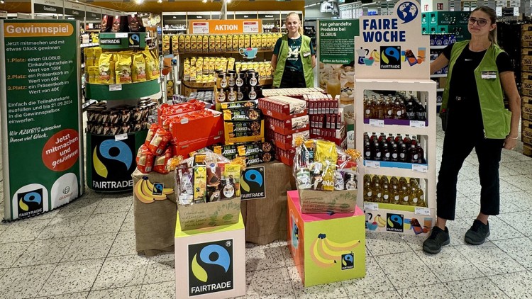 Verschiedene FAIRTRADE-Produkte auf Tischen, Regalen und Displays mit Gewinnspiel- sowie Aktionshinweisen bei GLOBUS.