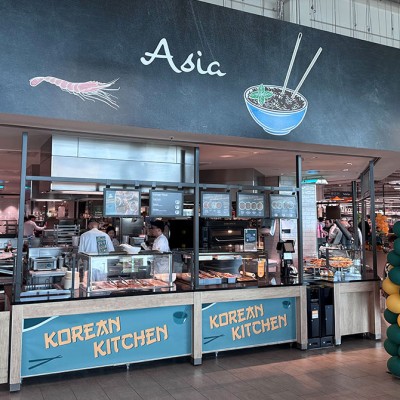 Die Theke „Korean Kitchen“ im GLOBUS Markt, darüber ein Asia-Logo mit Schale, Stäbchen und Garnele, links „VON HAND MIT HERZ GLOBUS“.