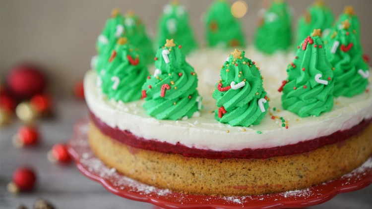 Torte mit grünem Sahnetopping in Form von Weihnachtsbäumen, dekoriert mit Sternen, Zuckerstreuseln und Zuckerstangen.