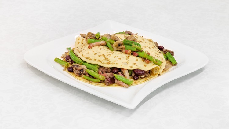 Zwei gefüllte Omeletts mit grünen Bohnen, Champignons, roten Bohnen und Speck auf einem weißen, eckigen Teller.