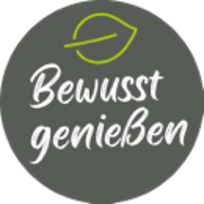 Grüner Kreis mit weißer Schrift „Bewusst genießen“, darüber ein hellgrünes Blatt, Hintergrund ist dunkelgrau.