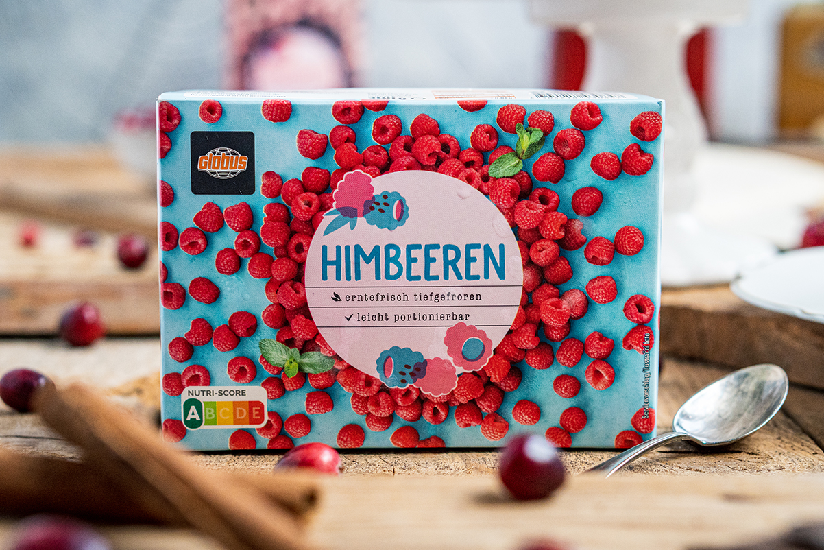 Auf einer blauen Verpackung von GLOBUS Himbeeren steht „erntefrisch tiefgefroren, leicht portionierbar“ mit Nutri-Score A.