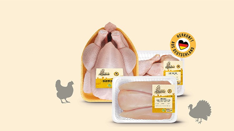 Drei Verpackungen von Hähnchenfleisch mit Label „Herkunft aus Deutschland“ auf beigem Hintergrund, daneben Silhouetten von Geflügel.