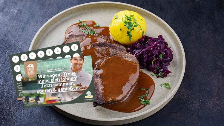 Ein Teller mit Braten in Soße, Kartoffelklößchen und Rotkohl, daneben eine GLOBUS Treuekarte mit Sammelpunkten und Werbetext.