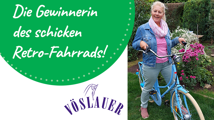 Die Gewinnerin hält ein hellblaues Retro-Fahrrad, daneben Schriftzug „VÖSLAUER“ und Text „Die Gewinnerin des schicken Retro-Fahrrads!“.