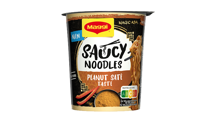 Maggi Saucy Noodles Becher mit Peanut Saté Taste, schwarzes und goldenes Design, Nutri-Score C und roter Chili als Dekoration.
