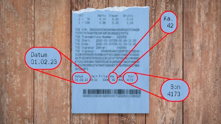 Ein blauer Kassenzettel mit Datum 01.02.23, Ka. 42, Bon 4173 und hervorgehobenen roten Markierungen auf Holzuntergrund.