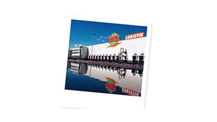 Weiße GLOBUS Logistikhalle mit Firmenlogo, Laderampen und Spiegelung im Wasser unter blauem Himmel.