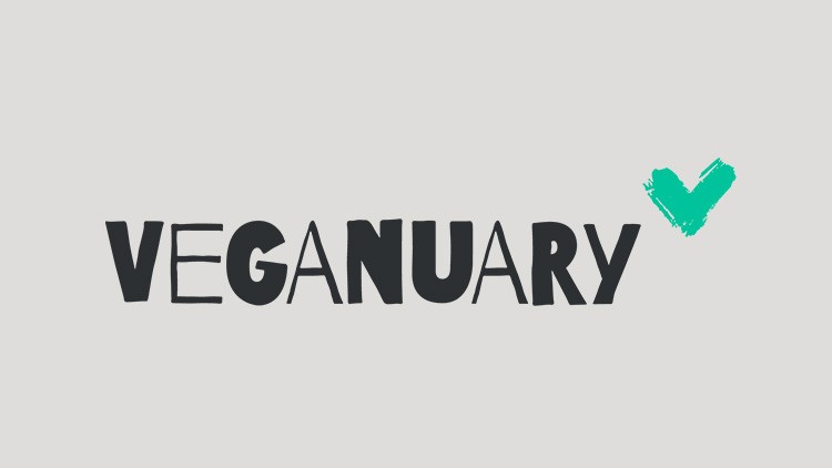 Schwarzer Schriftzug „VEGANUARY“ auf grauem Hintergrund mit einem türkisfarbenen Häkchen rechts oben.