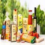 Verschiedene GLOBUS Bio-Produkte wie Öl, Mehl, Pasta und Gemüse vor einem Hintergrund mit grünem Blattwerk.