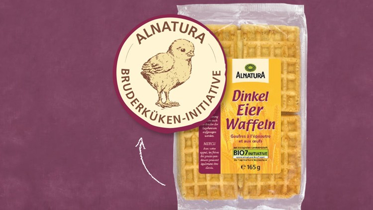 Packung Alnatura Dinkel Eierwaffeln vor lila Hintergrund, daneben rundes Logo der Alnatura Bruderküken-Initiative mit Kükenzeichnung.