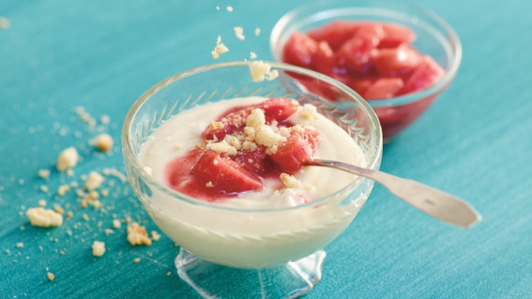 Zwei Glasschalen mit Vanillecreme und roten Fruchtstücken, dekoriert mit Streuseln, eine Schale hat einen Löffel.