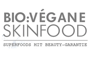 Logo mit grauem Text, BIO:VÉGANE SKINFOOD oben groß und darunter kleiner der Schriftzug SUPERFOODS MIT BEAUTY-GARANTIE.