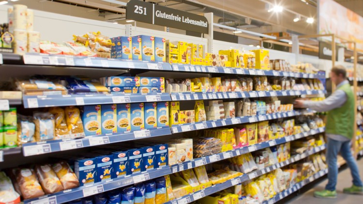 Regal mit glutenfreien Lebensmitteln im GLOBUS Markt, darüber ein Schild mit der Aufschrift „251 Glutenfreie Lebensmittel“.