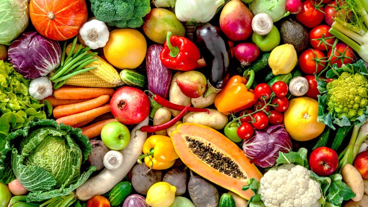 Verschiedenes frisches Obst und Gemüse wie Paprika, Karotten, Brokkoli, Papaya, Äpfel, Kopfsalat und Tomaten liegen nebeneinander.