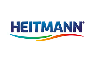 Das HEITMANN-Logo zeigt den blauen Schriftzug HEITMANN mit geschwungenen Linien in Grün, Orange und Rot darunter auf weißem Hintergrund.