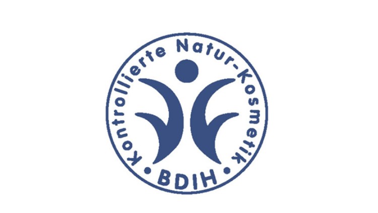 Rundes blaues Logo mit der Aufschrift „Kontrollierte Natur-Kosmetik BDIH“ und einer Figur aus drei abstrakten Formen in der Mitte.