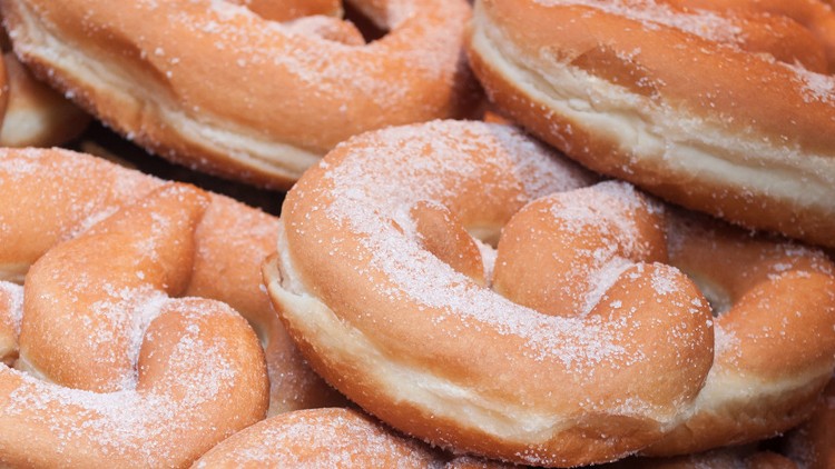 Mehrere frisch gebackene, gezuckerte Hefekringel liegen dicht beieinander.