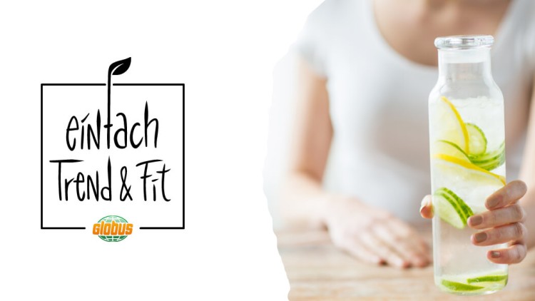 Blauer Bereich links, mittig „einfach Trend & Fit“ mit GLOBUS-Logo darunter, rechts Hand hält Karaffe mit Zitrone und Gurke.