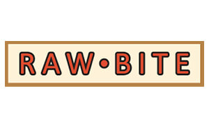 Das Logo zeigt in roten Buchstaben mit schwarzer Umrandung den Schriftzug RAW•BITE auf beigem Hintergrund mit braunem Rand.